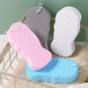 A set of three exfoliating bath sponges in pink, gray, and white are displayed on a light-colored surface.