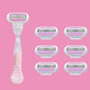 A set of five replacement shaving blades with pink and white handles and purple blades displayed against a pink background.