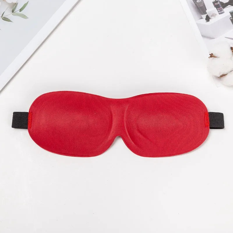 A bright red 3D sleep mask designed for light blocking is shown on a white surface.