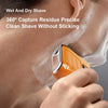 An orange portable electric shaver is being used to clean a person's face with shaving foam.