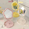 Un ensemble de miroirs floraux de bureau esthétiques en jaune, rose et blanc sur une surface blanche.