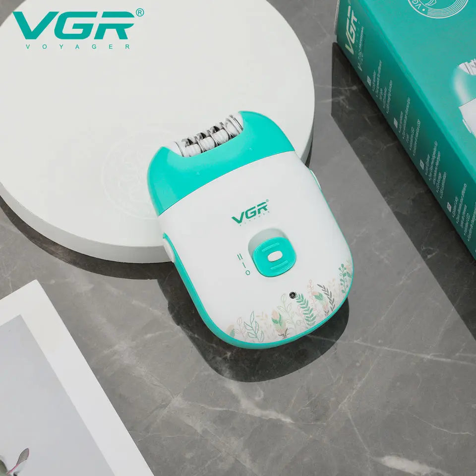 A white and teal rechargeable electric epilator device is shown on a gray surface next to its packaging box.