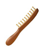 A wooden facial and scalp massage comb with multiple brass-colored teeth.