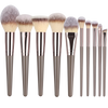 A set of various makeup brushes with fluffy and tapered bristles displayed against a black background.