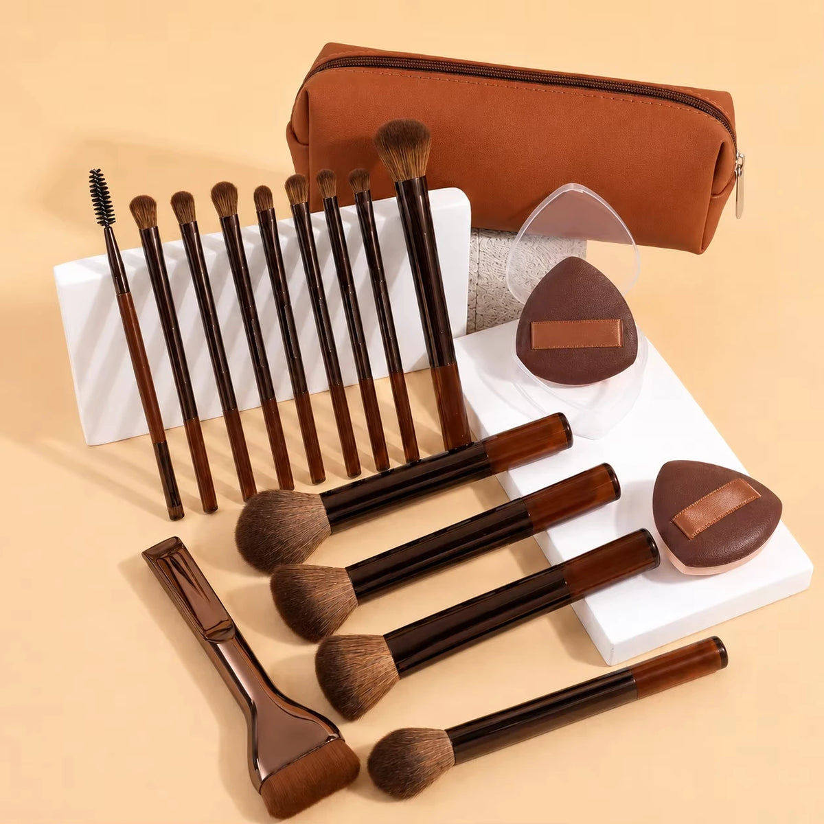 A set of 14 professional makeup brushes and sponges in brown and tan colors displayed on a white surface.