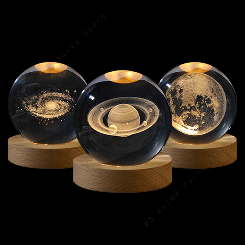 Three glass crystal balls with internal light illuminating celestial scenes on wooden stands.
