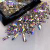 A collection of sparkling glass rhinestones and glitter scattered on a white surface.