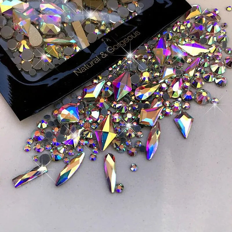 A collection of sparkling glass rhinestones and glitter scattered on a white surface.