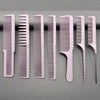 A set of seven white professional hair styling combs displayed in a row on a gray surface.