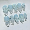 A set of light blue and white pink cat eye false nails featuring 3D floral and butterfly designs.