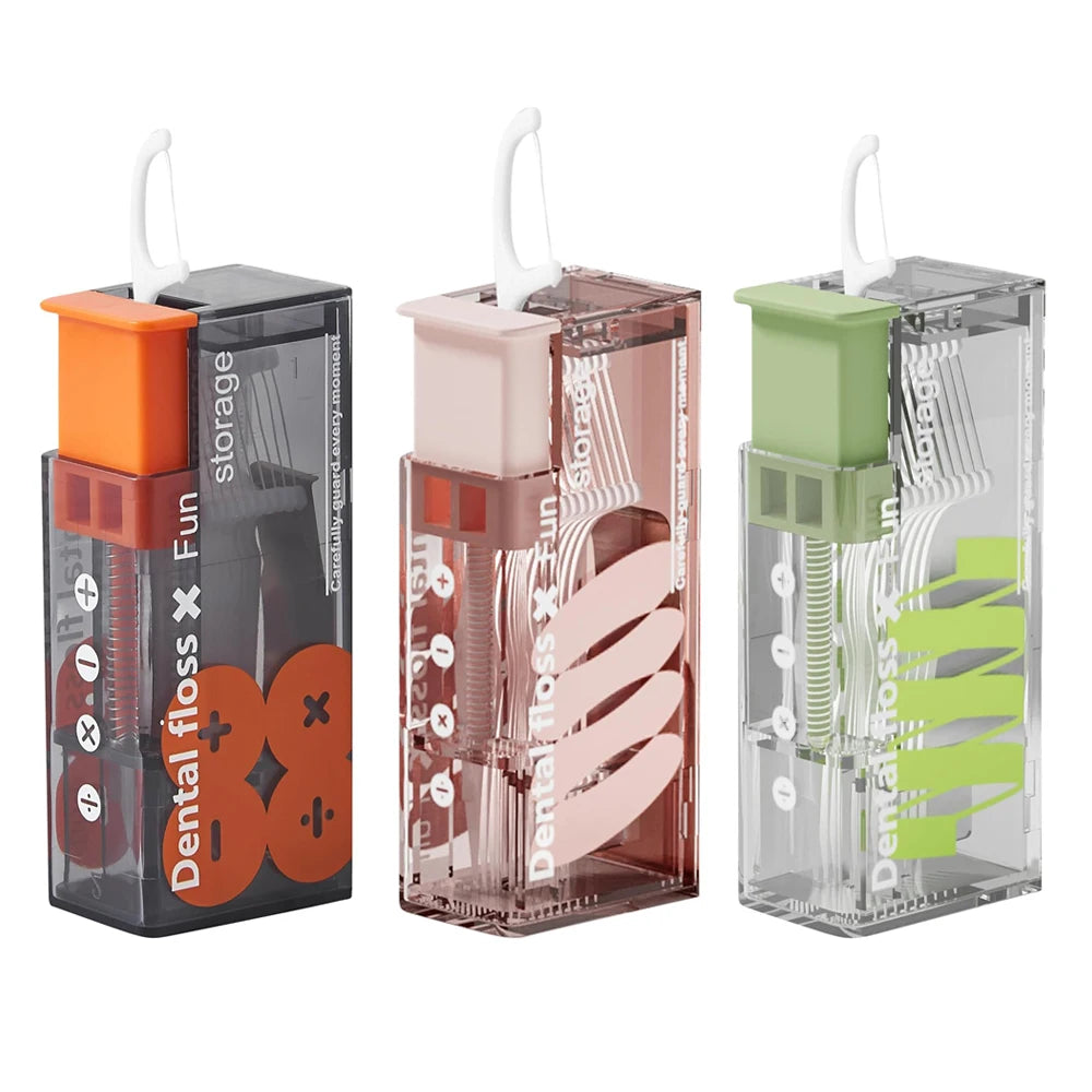 Automatische Zahnseide-Aufbewahrung und -Dispenser in orange, pink und grünem Kunststoffgefäße.