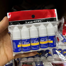 A hand holds a package of Antald Nail Glue for acrylic and press-on nails.