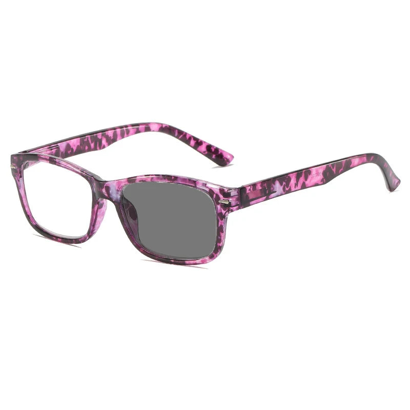 A pair of pink and purple photochromic reading glasses with a dark lens.