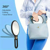 A person holds a light blue makeup mirror with a black frame and strap, demonstrating its folding and travel features.