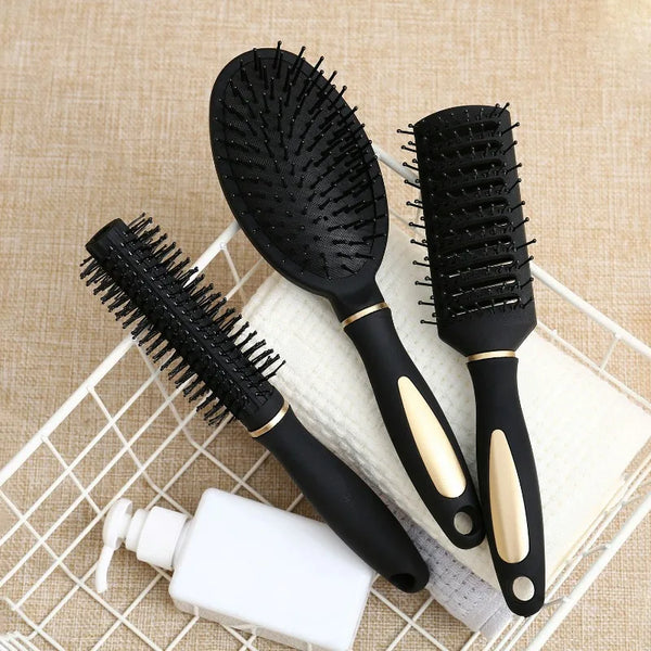 Ein Set schwarzer Kopfmassagebürsten für Entwirren und Haarpflege auf einem hellbeigen Handtuch.