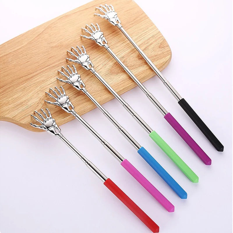 A set of telescoping stainless steel back massagers with colorful handles displayed on a wooden board.
