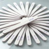 A fan of white dual-grit nail files arranged radially on a light gray surface.