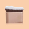 A precision hand-held foundation makeup brush with soft gray and white bristles in a beige holder.