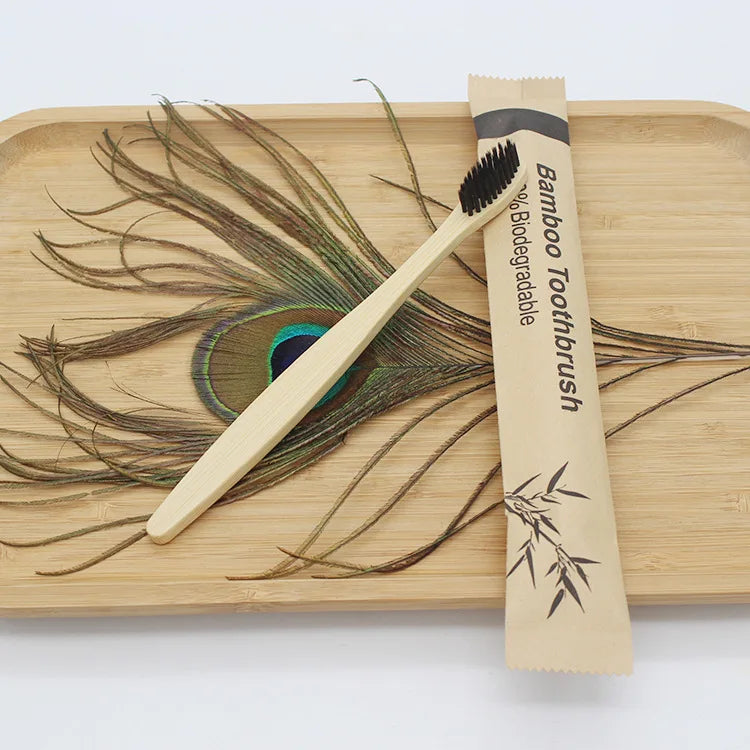 A bamboo toothbrush is shown resting on a wooden cutting board with a design of flowing hair.