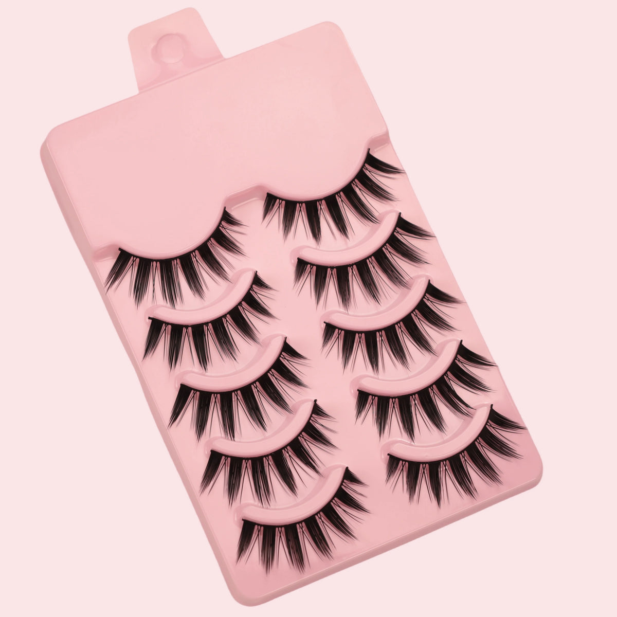 A pink plastic tray holding five pairs of dramatic manga style false eyelashes