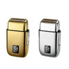 A close-up view of a gold and silver reciprocating electric shaver with a textured head.