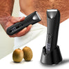 A hand holds a black precision electric body and hair trimmer next to fresh citrus fruits.