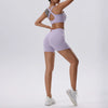Una mujer modela un conjunto deportivo de yoga y gimnasio de arriba y abajo, lavable y que se seca rápido, color lavanda.