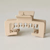 A beige non-slip hat claw clip with a strong hold design for securing baseball caps.