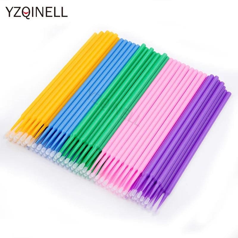 A collection of colorful bulk eyelash extension cleaning swabs in yellow, blue, green, and pink.