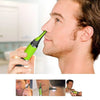 A man is using a green rechargeable nose and ear hair trimmer on his face.