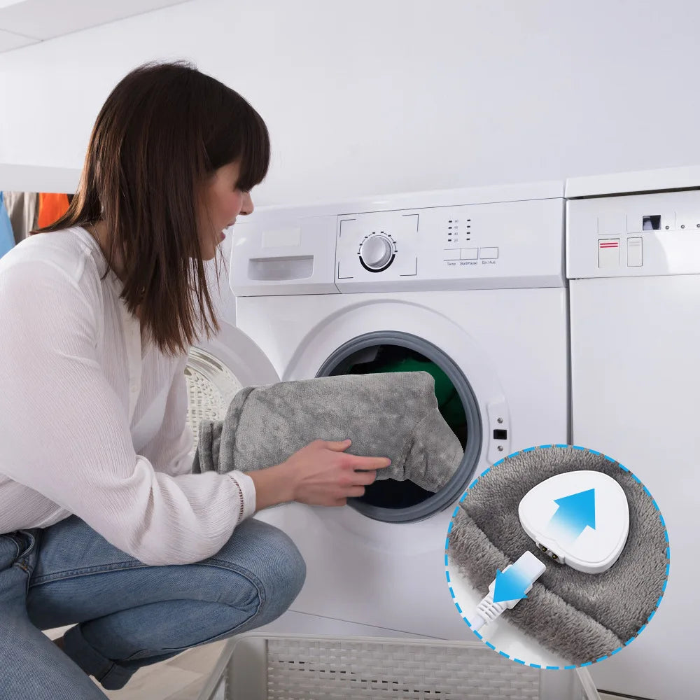 A woman is using an electric heated neck and shoulder massager on a white washing machine.