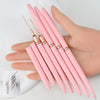 Une main tient un ensemble de pinceaux pour liner d'ongles roses avec des pointes fines.