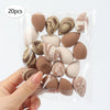 A hand holds a clear plastic bag containing 20 reusable expandable makeup sponges with marbled brown and beige patterns.