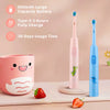 A pink and blue rechargeable electric toothbrush for kids is shown next to a strawberry on a light surface.