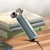 A close-up of a silver electric shaver with a magnetic detachable head resting on a stack of books.