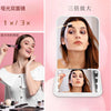 A woman uses a compact LED makeup mirror with 3X magnification to apply makeup.