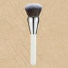 A silver and white professional makeup brush with a dense, grey-tipped bristles.