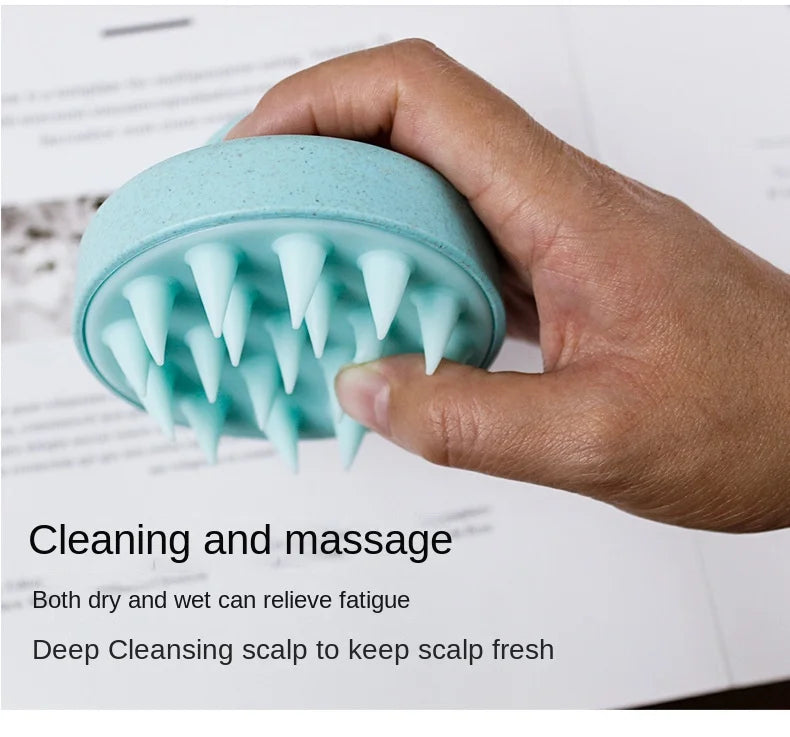 A hand holds a light blue wet and dry scalp massage brush with pointed bristles, demonstrating its use for cleaning and massa
