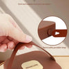 Une boîte de rangement portable en ABS marron avec une sangle amovible, tenue par une main.