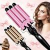 Un rizador de cabello de triple barril de cerámica rosa junto al cabello de una modelo.