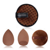 A black sponge with a brown textured surface and three round makeup sponges in various shades of brown.