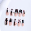 A set of gothic Y2K press-on nails featuring black and pink designs with cross and bow embellishments.