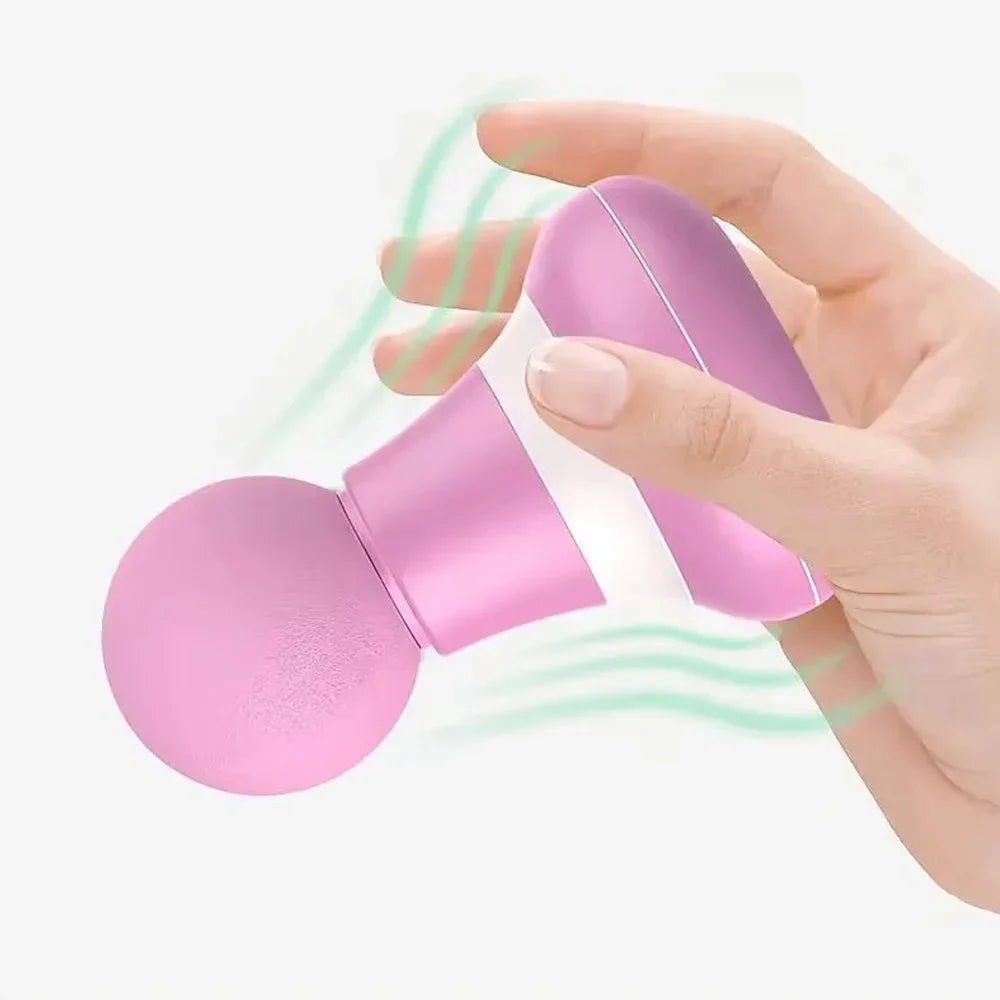 A hand is holding a pink mini portable massage gun, showing the device's design and size.