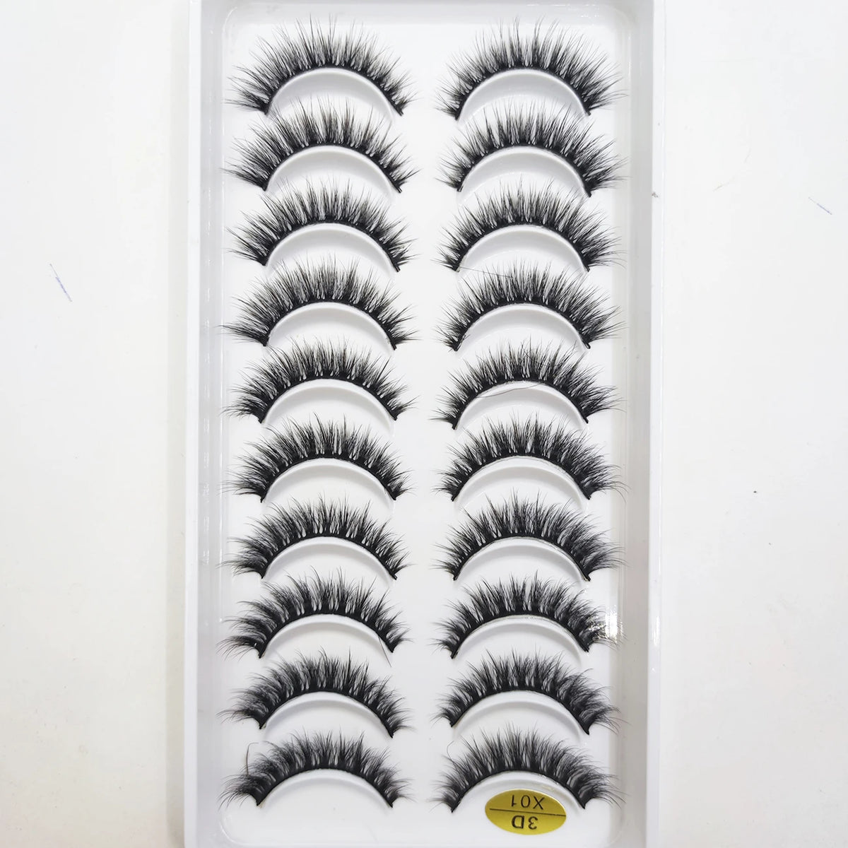 A tray of natural 3D mink false eyelashes displayed in a white plastic container.