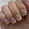 A close-up of a hand displaying press-on acrylic flower nails with soft pink and green accents.