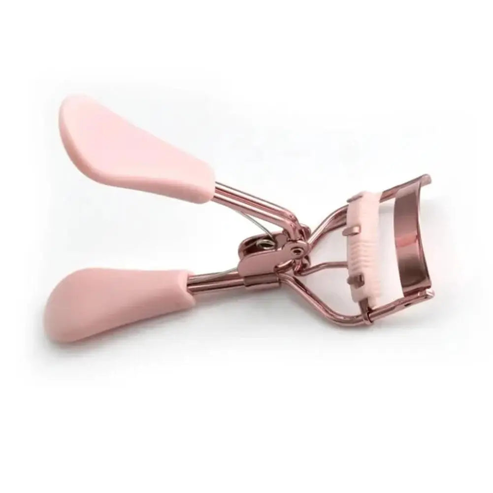 Un recourbe-cils rose professionnel avec une brosse, montré sur fond blanc.
