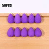 Fifty purple makeup sponge puffs arranged in two rows on a wooden surface.