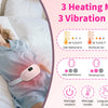 A woman is lying in bed wearing a pink portable heated massage belt for pain relief.