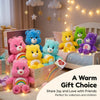 A collection of colorful Care Bears plush toys displayed on a wooden box with string lights.