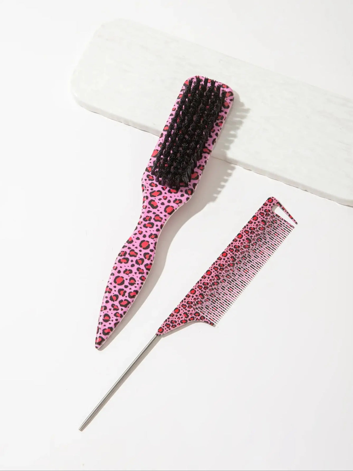 A set of two leopard print pointed tail hair combs, one black and one pink.